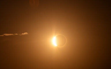 Fototapeta premium Partial Solar Eclipse Shining Through a Golden Hazy Sky