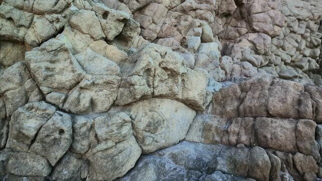 Detailed volcanic basalt rock texture with rugged natural surface, dark stone patterns, geological formation, weathered volcanic terrain and natural geological background