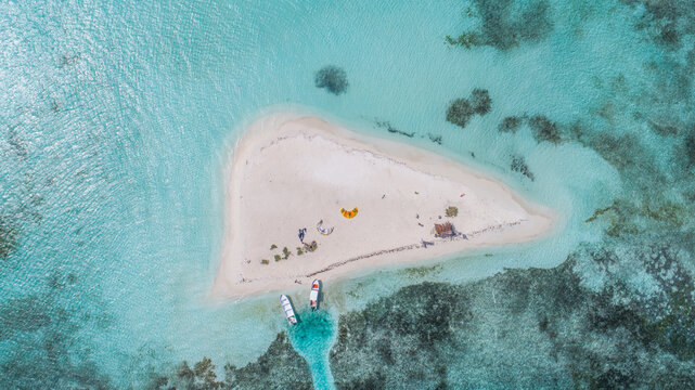 Aerial view of Los Roques archipelago featuring a sandy cay in turquoise Caribbean waters with moored boats and kitesurfing gear Los Roques, Dependencias Federales, Venezuela.