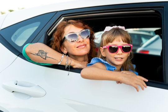 Mother and daughter enjoying road trip vacation, wearing sunglasses