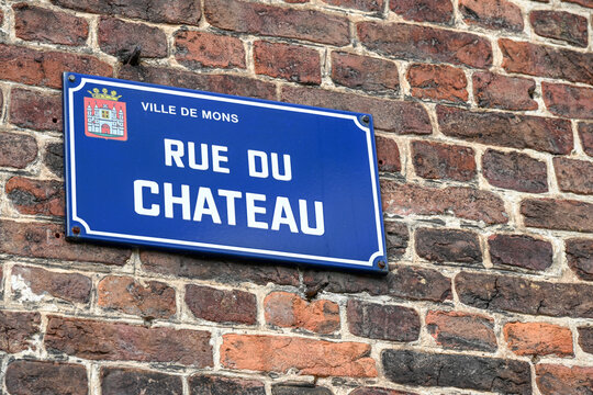 plaque signal&eacute;tique de la rue du ch&acirc;teau dans la ville de Mons, en Belgique. Fix&eacute;e sur un mur de briques rouges et sombres 