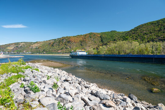 Dry riverbed of rhine river, extreme drought in Europe, impact freight transport and hinder shipping, low water level, upper middle valley near Kaub, Germany