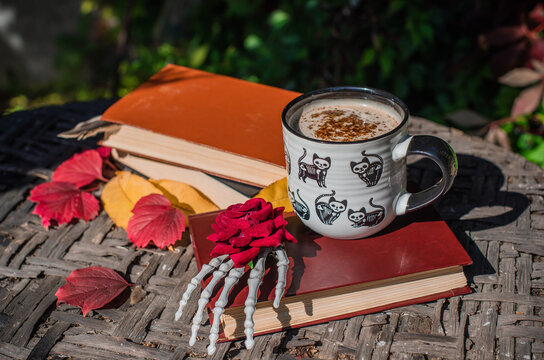 Halloween Still Life with Pumpkin, Skeleton Hand and Ceramic Cat Mug