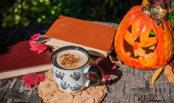 Halloween Still Life with Pumpkin, Skeleton Hand and Ceramic Cat Mug