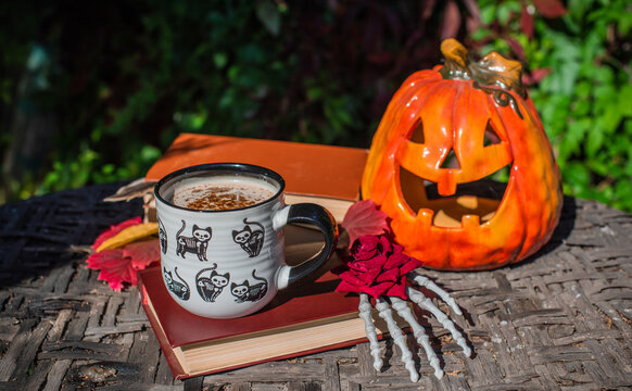 Halloween Still Life with Pumpkin, Skeleton Hand and Ceramic Cat Mug