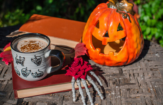Halloween Still Life with Pumpkin, Skeleton Hand and Ceramic Cat Mug