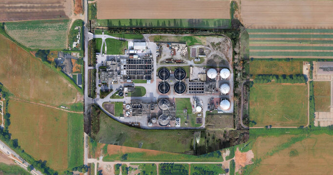 Aerial view of a water treatment facility with circular tanks, industrial infrastructure, and surrounding agricultural fields in Richmond, British Columbia, Canada.