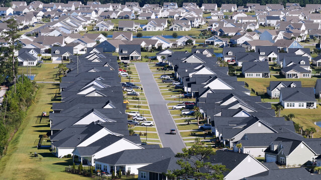 Aerial view of a suburban residential neighborhood with rows of houses, paved streets, and parked cars in Myrtle Beach, South Carolina, United States.