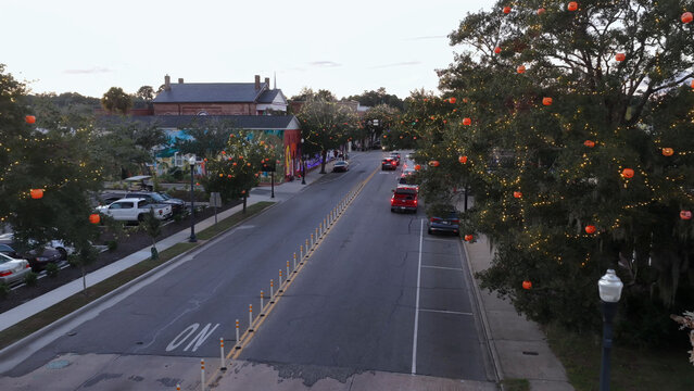 Aerial view of a street in Conway decorated with festive pumpkin lights in the trees during the evening in Conway, South Carolina, United States.