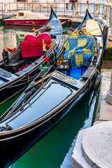 gondolas in venetian canal decorated in traditional vintage style of Venice and old architecture buildings on background © Yaroslav