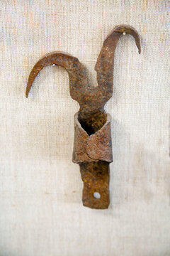 Antique metal boat hook with hooks on a light background. The subjects are old technologies. World tourism.