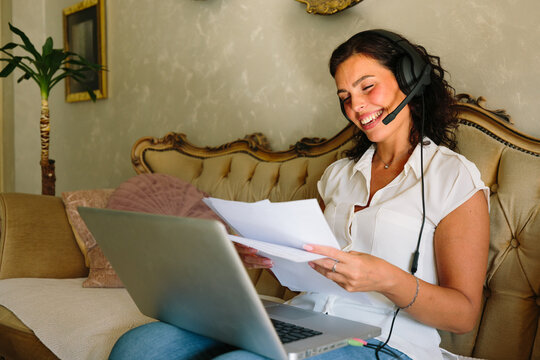 Smiling woman reading documents while working from home