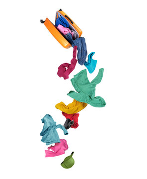 Open orange suitcase in mid-air with colorful casual clothes and accessories falling down, isolated on white background