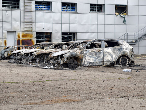 A parking lot full of charred and burned cars. Ruined vehicles in a parking lot after a devastating blaze