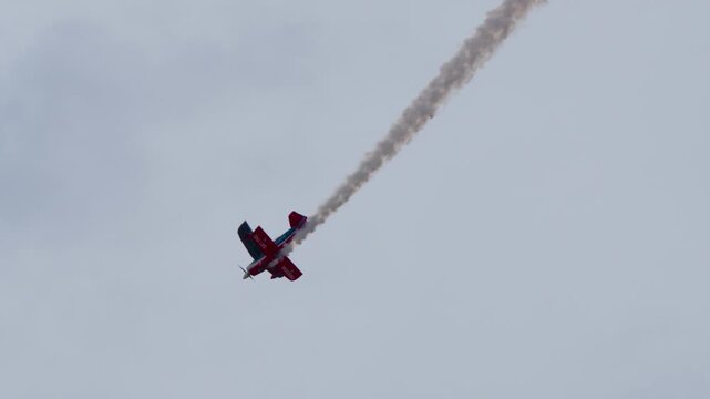 Biplane doing stunts with smoke at an airshow