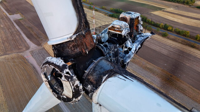 Aerial view of a severely damaged and charred wind turbine hub with burnt blades, surrounded by agricultural fields in Vladimirovac, Vojvodina, Serbia.