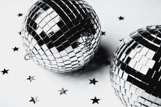 Two Shiny Disco Balls With Star Confetti On White Background