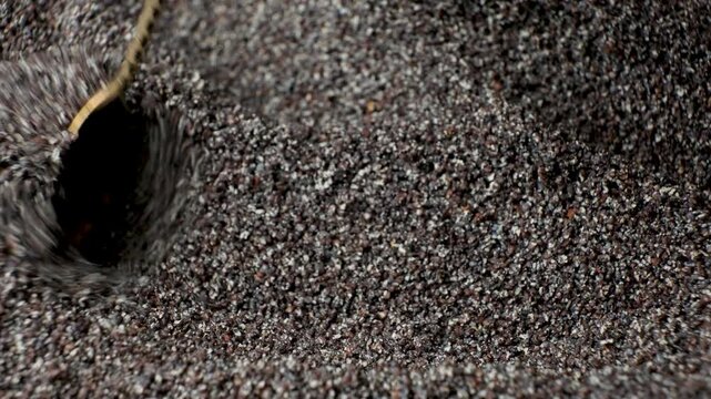 Stirring ground poppy seeds with spoon close up macro shot