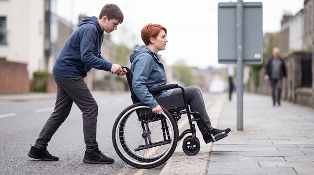 Teenage boy helps a wheelchair user over a high kerb
