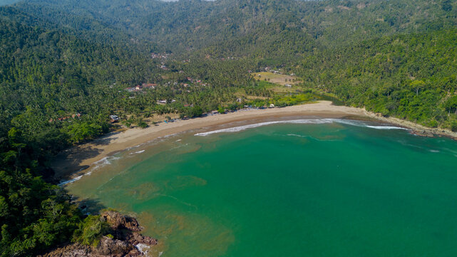 Aerial view of Wedi Awu beach bay with turquoise ocean and lush green hills in Malang East Java