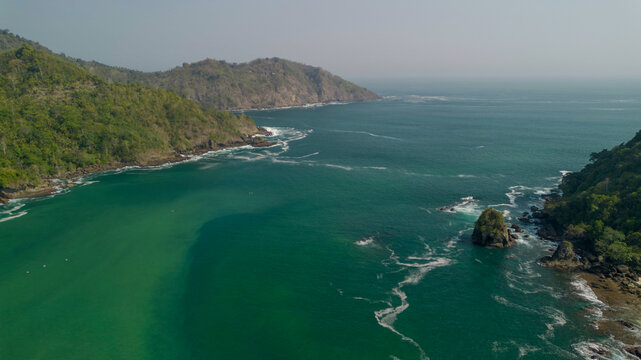 Aerial view of Wedi Awu beach bay with turquoise ocean and lush green hills in Malang East Java