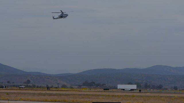 Military helicopter hovering over a runway during an airshow