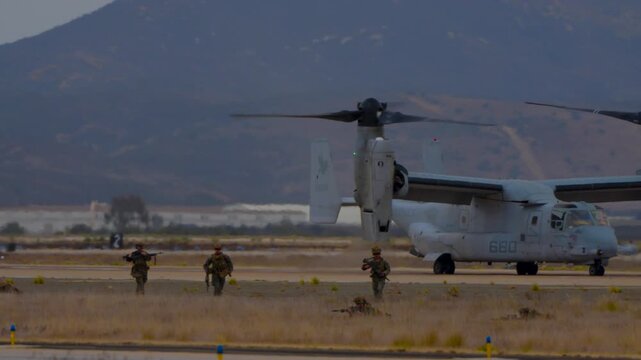 Military troops storming out of a osprey aircraft during a demonstration