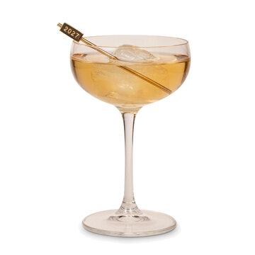 Coupe cocktail with a gold 2027 stirrer and ice