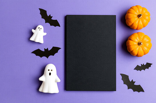 Vertical blank photo frame with halloween ghost and pumpkin props on purple background