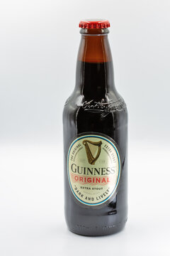 Guinness Original Extra Stout beer bottle closeup on white.