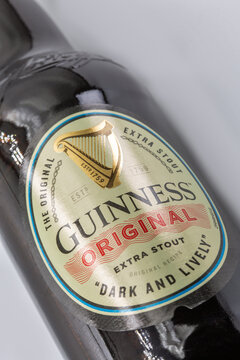 Guinness Original Extra Stout beer bottle label closeup on white.