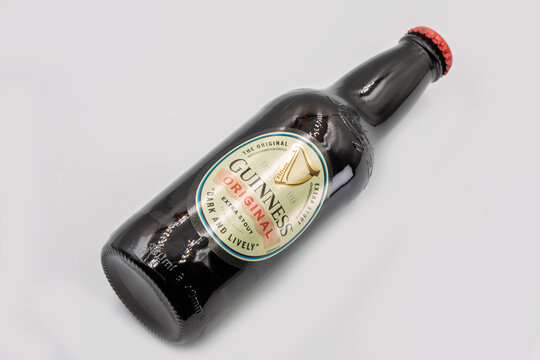 Guinness Original Extra Stout beer bottle closeup on white.