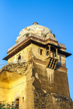 View of the historic Rohtas Fort featuring intricate stone architecture, a prominent dome, and weathered walls under a clear blue sky in Dina, Punjab, Pakistan.
