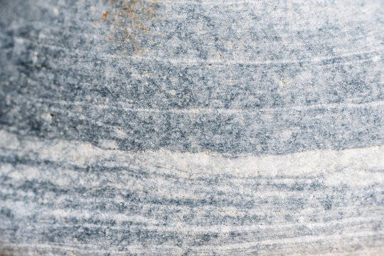 Gros plan macro sur la texture z&eacute;br&eacute;e d'un galet gris et blanc 
