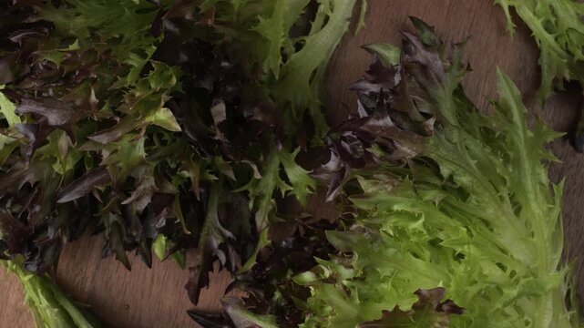 Fresh red leaf lettuce rotating on a wooden surface