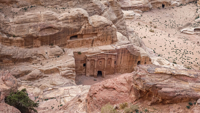 View of the Monastery, an ancient rock-cut temple carved into sandstone cliffs at the Petra archaeological site, surrounded by arid desert landscape in Wadi Musa, Ma'an Governorate, Jordan.