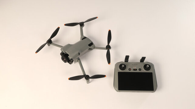 A quadcopter drone with smart remote controller on a white background.