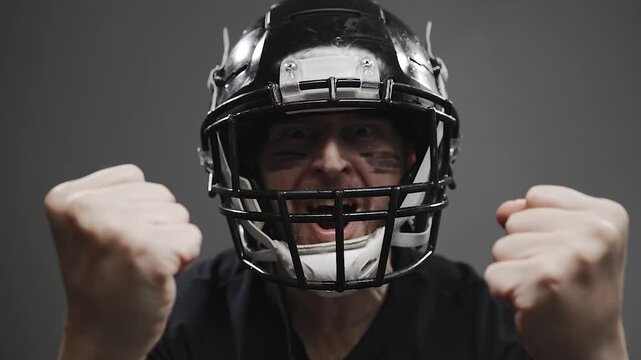 Dynamic video footage of an American football player expressing raw emotion, shouting, and celebrating a winning moment after an intense game. Features dramatic energy with sweat and water droplets fl