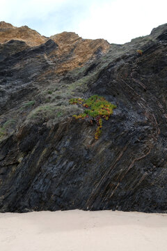 Majestic coastal rock cliff along the Rota Vicentina trail in Portugal. Wild Atlantic ocean coastline, geology and hiking travel.