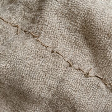 Macro view of crooked hand-sewn stitches on natural linen showing