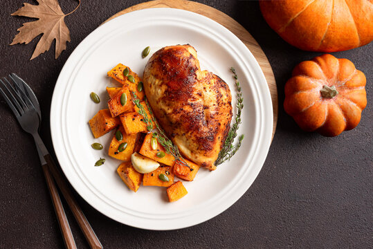Autumn meal: roasted chicken breast and pumpkin with herbs