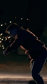 A man makes a flip in the air, tricks of martial arts in night city, slow-motion