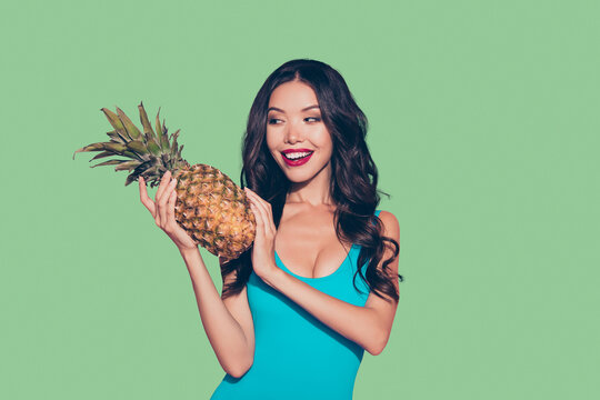 Portrait of nice cheerful cute foxy cunning girlish adorable attractive glamorous wavy-haired lady beaming smile holding ananas in hands isolated over pink background