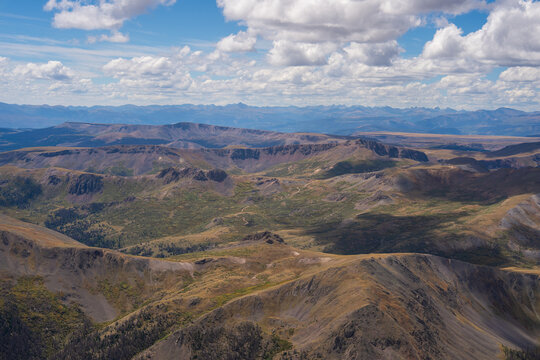 View of the rugged San Juan Mountains landscape near San Luis Peak, featuring expansive ridges, deep valleys, and rocky terrain under a bright sky in Creede, Colorado, United States.
