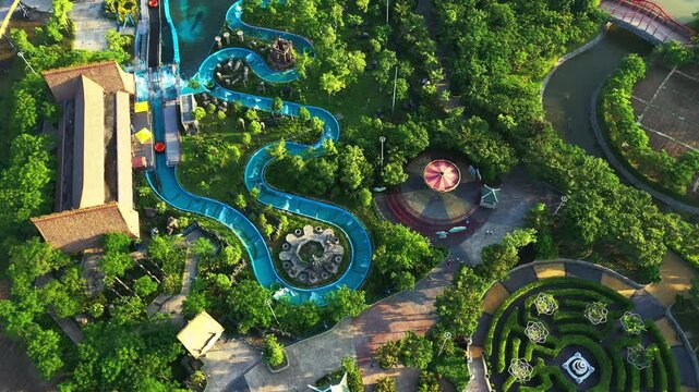 Water slide, drone and amusement park for outdoor fun time, adventure and leisure. Holiday, rollercoaster and tourist attraction for entertainment, urban area and greenery with carousel for summer