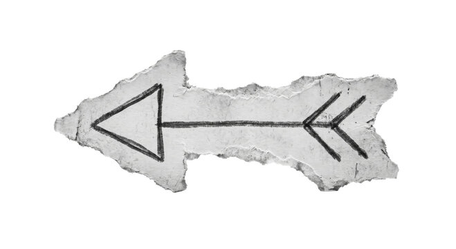Hand drawn arrow symbol on torn paper fragment, pointing left