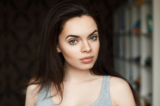 Young beautiful brunette girl in a t-shirt on the background of the room