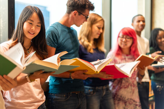 Diverse group reading books together.