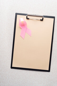 Clipboard with Pink Ribbon on Surface