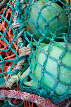 View of colorful fishing nets and green plastic floats used in the commercial fishing industry in Canada.